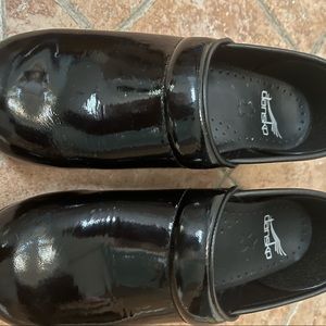 Black patent leather clogs by Dansko